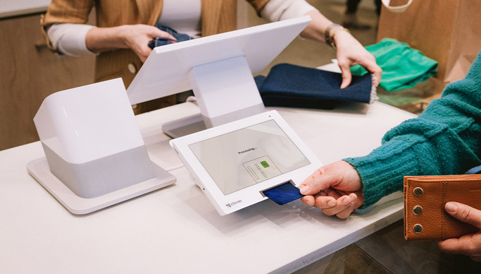 A customer paying by card at a shop counter